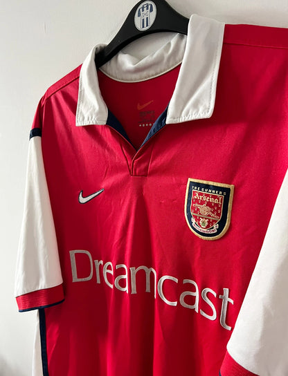 Maillot de foot vintage domicile rouge et blanc d'arsenal de la saison 1999/2000. On peut retrouver l'équipementier Nike et le sponsor JVC. Le maillot est floqué du numéro 10 Dennis Bergkamp. Il s'agit d'un maillot authentique d'époque.