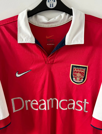 Maillot de foot vintage domicile rouge et blanc d'arsenal de la saison 1999/2000. On peut retrouver l'équipementier Nike et le sponsor JVC. Le maillot est floqué du numéro 10 Dennis Bergkamp. Il s'agit d'un maillot authentique d'époque.