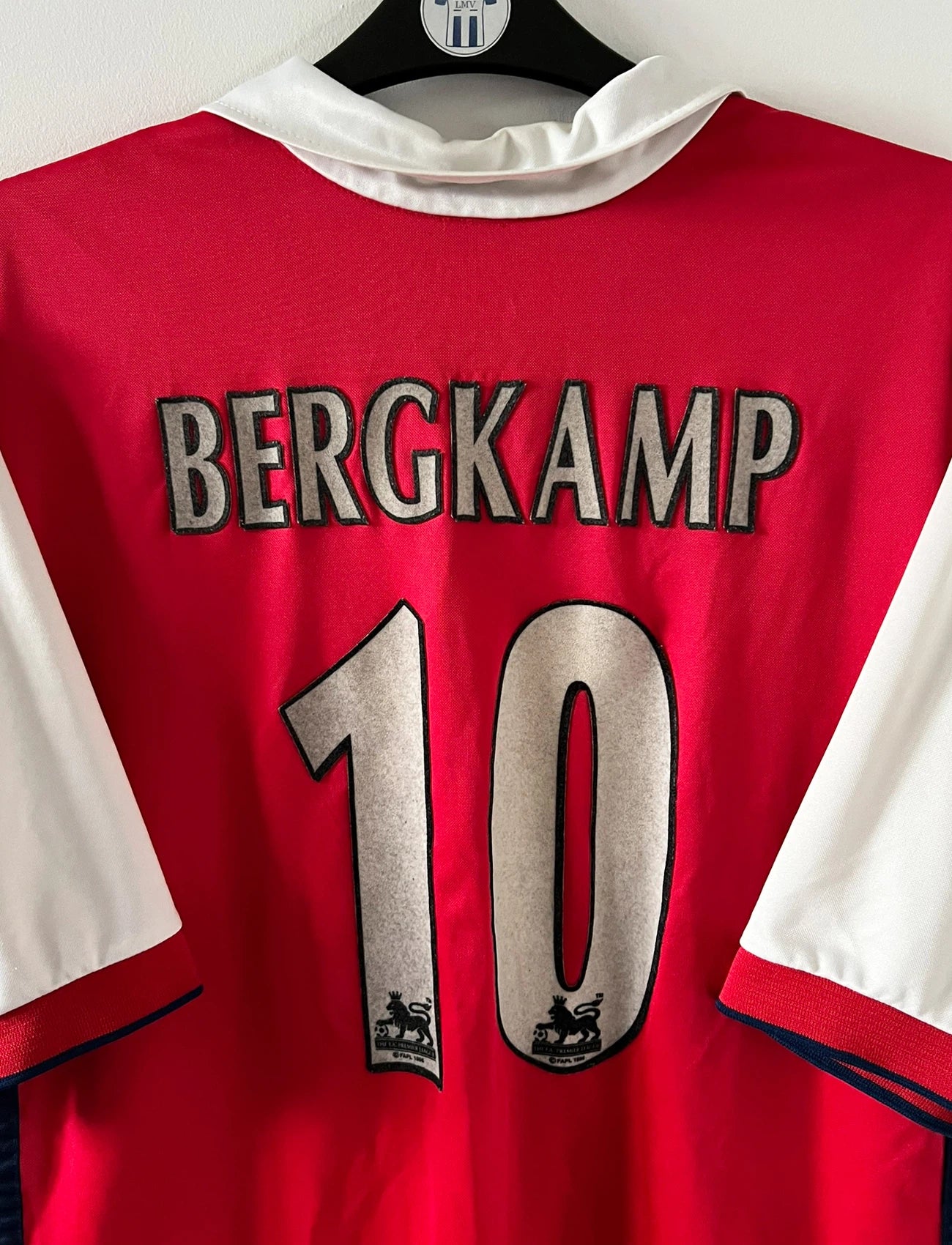 Maillot de foot vintage domicile rouge et blanc d'arsenal de la saison 1999/2000. On peut retrouver l'équipementier Nike et le sponsor JVC. Le maillot est floqué du numéro 10 Dennis Bergkamp. Il s'agit d'un maillot authentique d'époque.