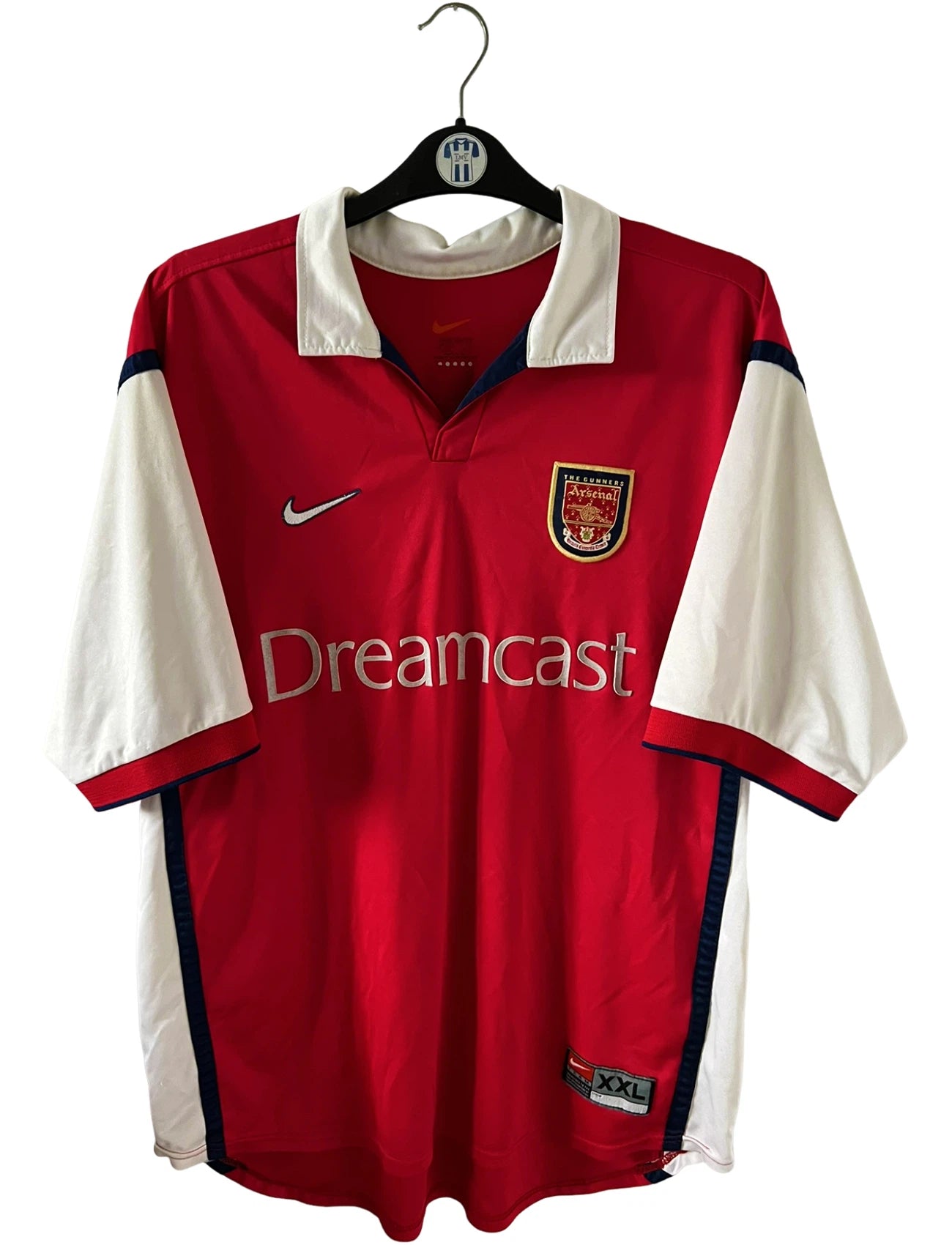 Maillot de foot vintage domicile rouge et blanc d'arsenal de la saison 1999/2000. On peut retrouver l'équipementier Nike et le sponsor JVC. Le maillot est floqué du numéro 10 Dennis Bergkamp. Il s'agit d'un maillot authentique d'époque.