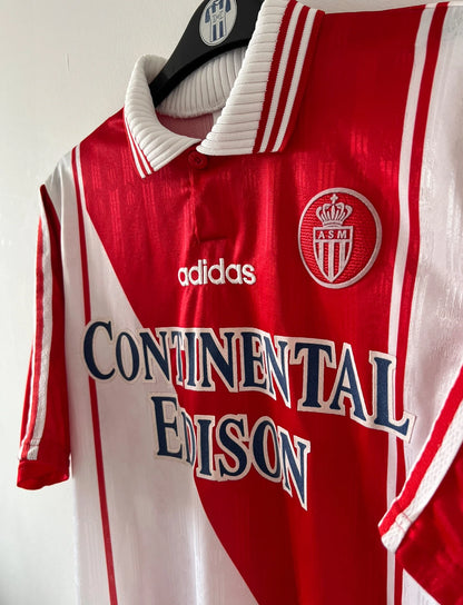 Maillot de foot vintage domicile rouge et blanc de l'AS Monaco 1997/1998. n peut retrouver l'équipementier Adidas et le sponsor Continental Edison. Il s'agit d'un maillot authentique d'époque.