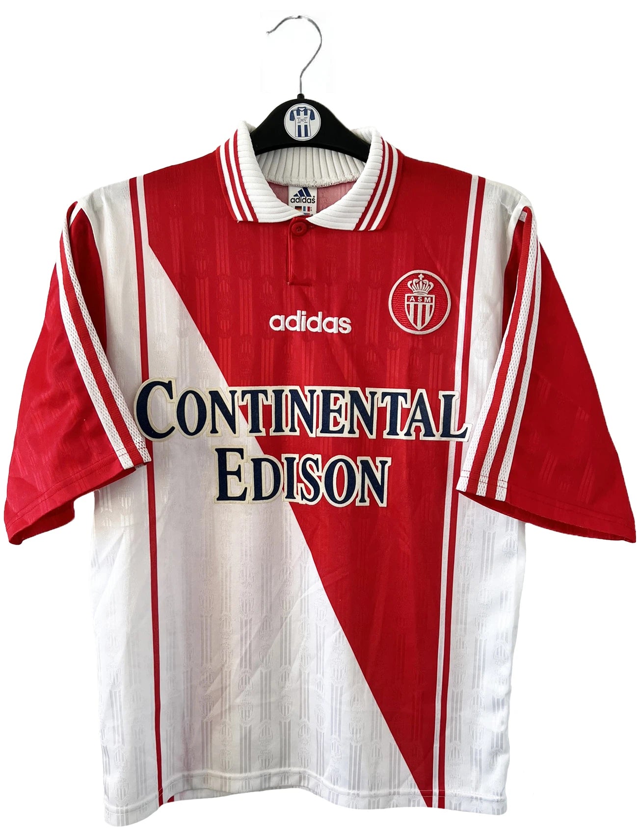 Maillot de foot vintage domicile rouge et blanc de l'AS Monaco de la saison 1997/1998. On peut retrouver l'équipementier Adidas et le sponsor Continental Edison. Il s'agit d'un maillot authentique d'époque.