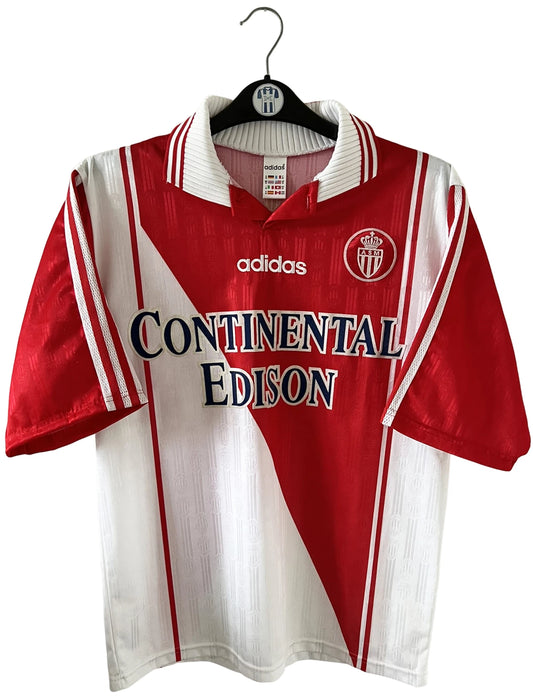Maillot de foot vintage domicile rouge et blanc de l'as monaco saison 1997/1998. On peut retrouver l'équipementier Adidas et le sponsor Continental Edison. Il s'agit d'un maillot authentique d'époque.