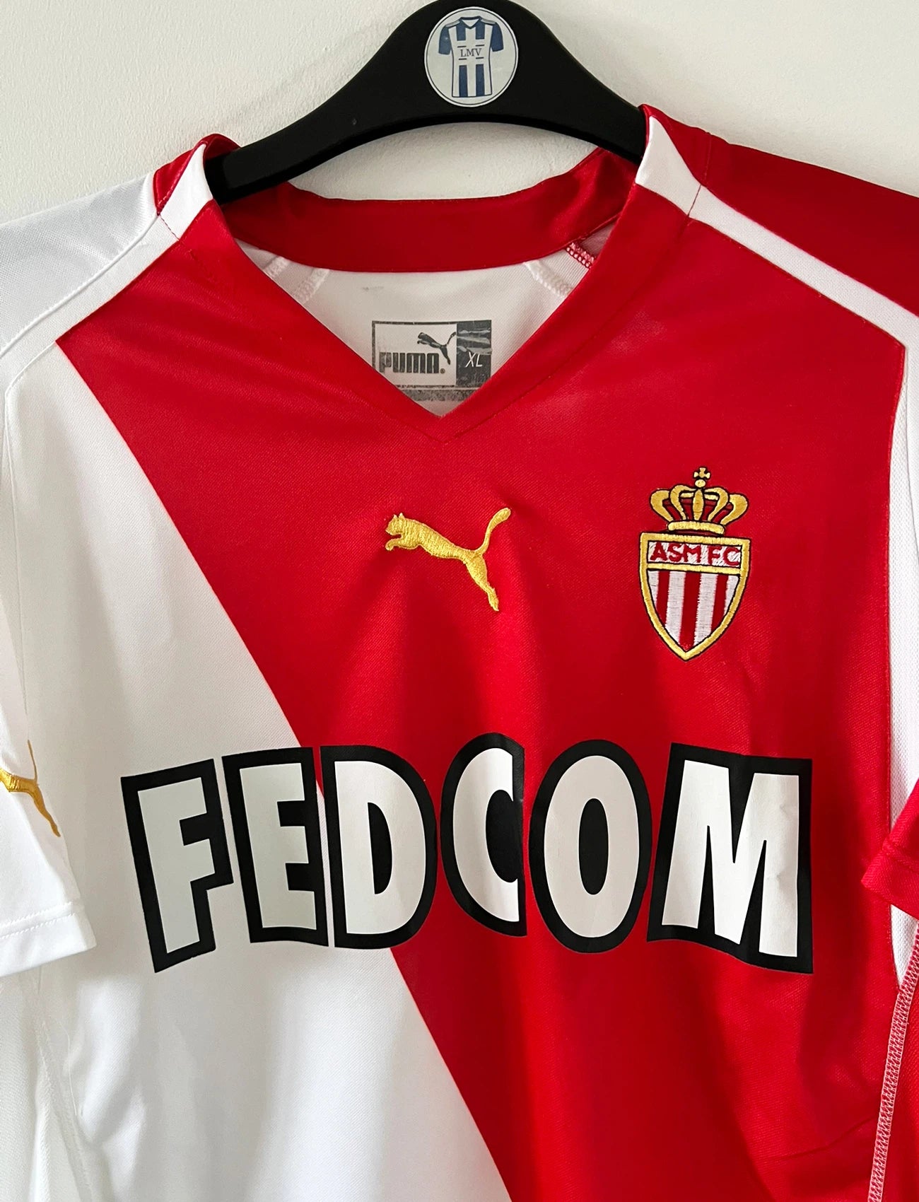 Maillot de foot vintage domicile blanc et rouge de l'as monaco 2004/2006. On peut retrouver l'équipementier Puma et le sponsor Fedcom. Il s'agit d'un maillot authentique d'époque.