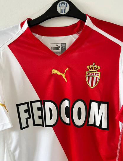 Maillot de foot vintage domicile blanc et rouge de l'as monaco 2004/2006. On peut retrouver l'équipementier Puma et le sponsor Fedcom. Il s'agit d'un maillot authentique d'époque.