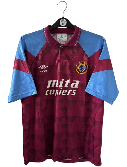 Maillot de foot vintage domicile rouge et bleu d'aston villa de la saison 1990/1992. On peut retrouver l'équipementier Umbro et le sponsor Mita Copiers. Il s'agit d'un maillot authentique d'époque.