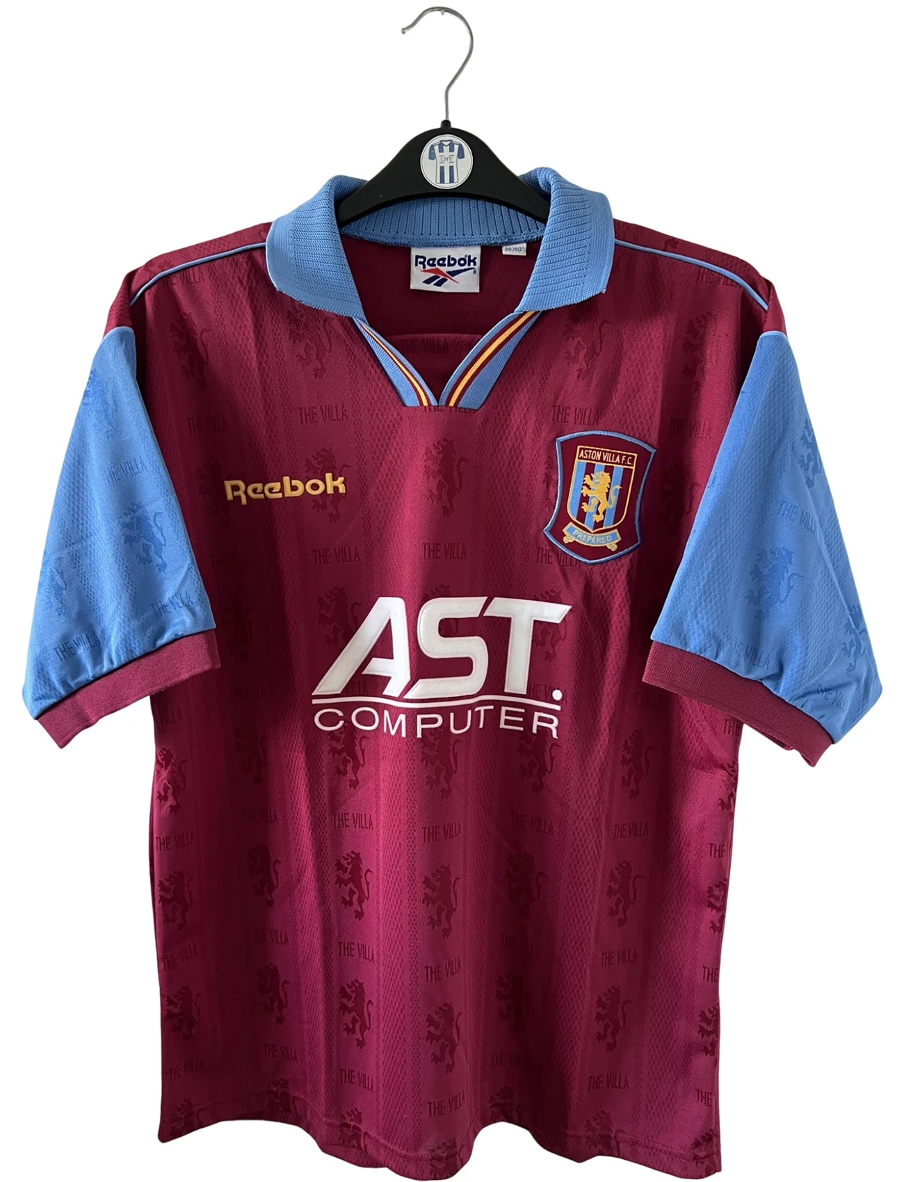 Maillot de foot vintage domicile rouge et bleu d'aston villa de la saison 1995/1997. On peut retrouver l'équipementier Reebok et le sponsor AST Computer. Il s'agit d'un maillot authentique d'époque.