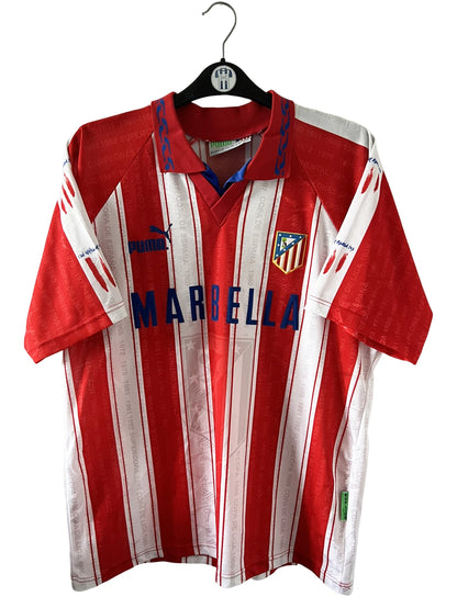 Maillot de foot vintage domicile rouge et blanc de l'atletico madrid 1995/1996. On peut retrouver l'équipementier Puma et le sponsor Marbella. Il s'agit d'un maillot authentique d'époque.