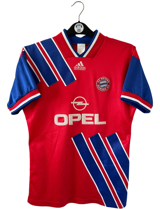 Maillot de foot vintage domicile rouge et bleu du Bayern Munich de la saison 1993-1994. On peut retrouver l'équipementier Adidas et le sponsor Opel. Il s'agit d'un maillot authentique d'époque.