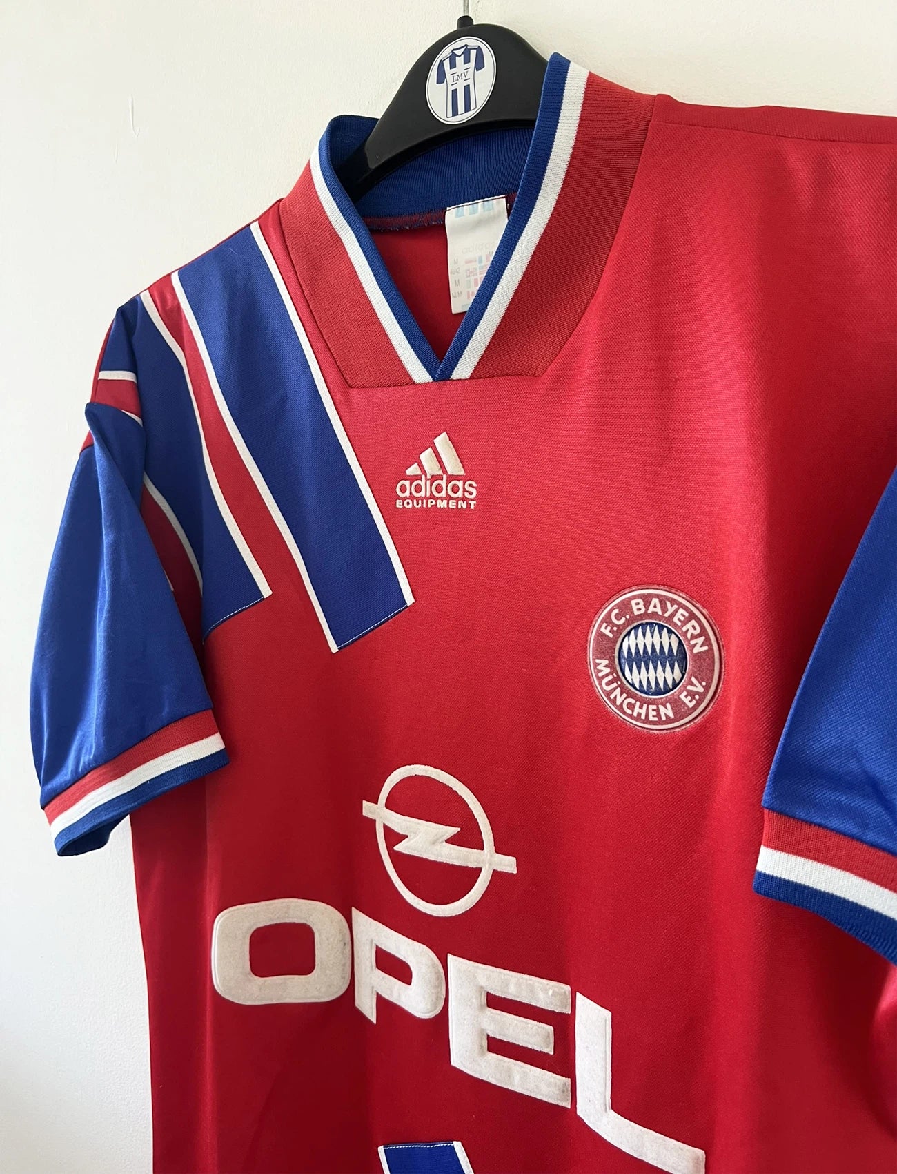 Maillot de foot vintage domicile rouge et bleu du Bayern de la saison 1993/1995. On peut retrouver l'équipementier Adidas et le sponsor Opel. Il s'agit d'un maillot authentique d'époque.