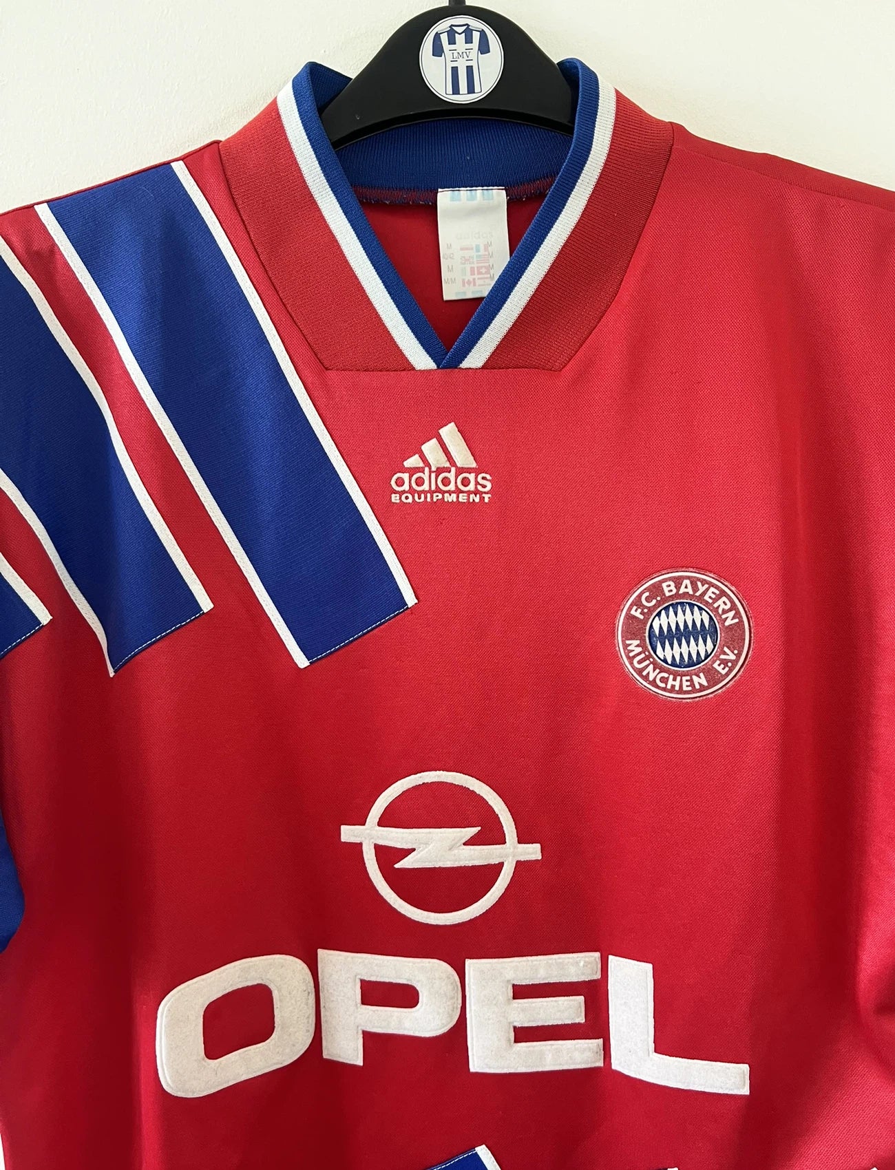 Maillot de foot vintage domicile rouge et bleu du Bayern de la saison 1993/1995. On peut retrouver l'équipementier Adidas et le sponsor Opel. Il s'agit d'un maillot authentique d'époque.