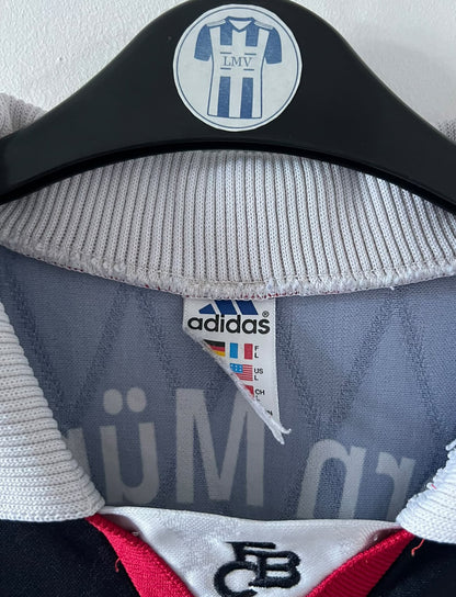 Maillot de foot vintage domicile noir du bayern 1997/1998. On peut retrouver l'équipementier Adidas et le sponsor Opel. Il s'agit d'un maillot authentique d'époque.