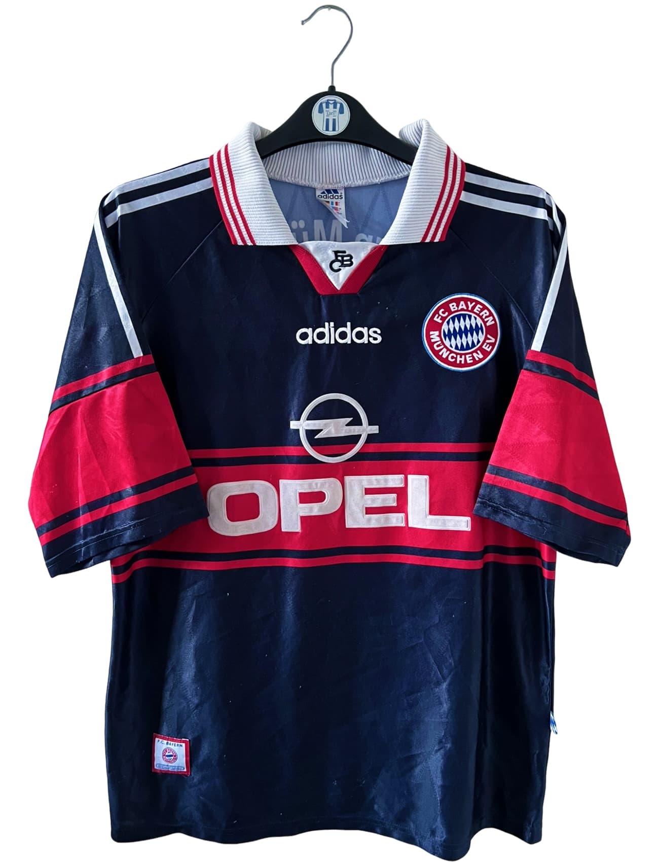 Maillot de foot vintage domicile noir du bayern 1997/1998. On peut retrouver l'équipementier Adidas et le sponsor Opel. Il s'agit d'un maillot authentique d'époque.
