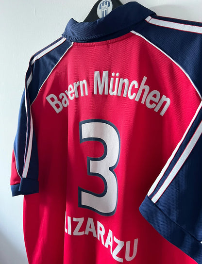 Maillot de foot vintage domicile rouge du Bayern Munich 1999/2001. On peut retrouver l'équipementier Adidas et le sponsor Opel. Le maillot est floqué du numero 3 Bixente Lizarazu. Il s'agit d'un maillot authentique d'époque.