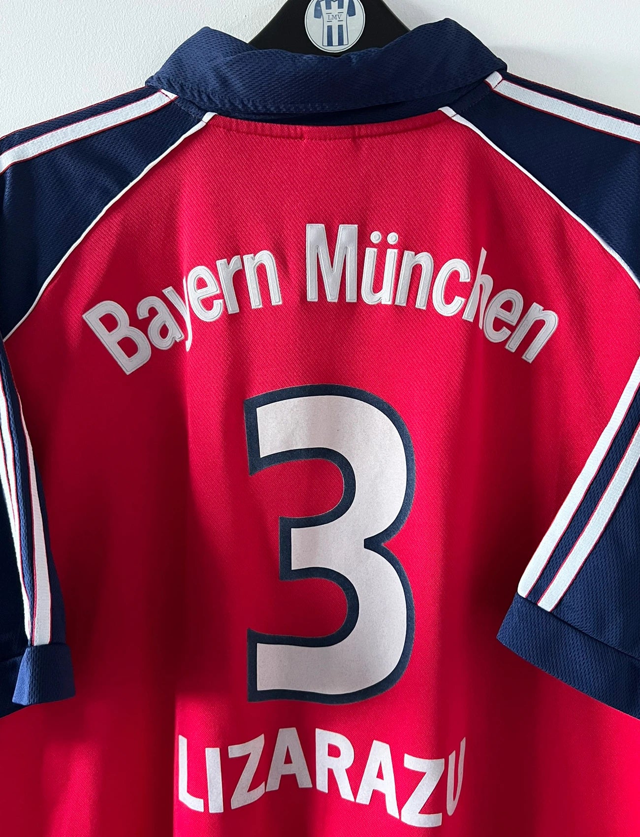 Maillot de foot vintage domicile rouge du Bayern Munich 1999/2001. On peut retrouver l'équipementier Adidas et le sponsor Opel. Le maillot est floqué du numero 3 Bixente Lizarazu. Il s'agit d'un maillot authentique d'époque.