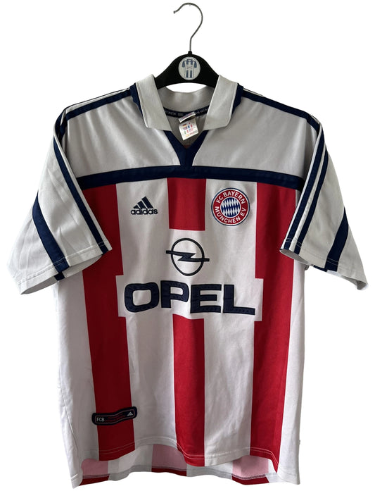 Maillot de foot vintage extérieur blanc et rouge du Bayern Munich 2000/2002. On peut retrouver l'équipementier Adidas et le sponsor Opel. Il s'agit d'un maillot authentique d'époque.