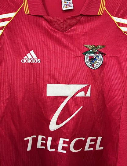 Maillot de foot vintage domicile rouge du Benfica de la saison 1998/1999. On peut retrouver l'équipementier Adidas et le sponsor Telecel. Il s'agit d'un maillot authentique d'époque.