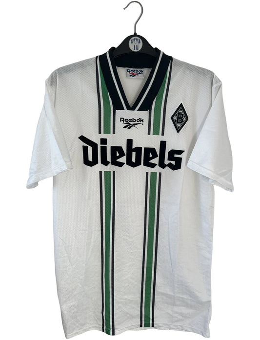 Maillot de foot vintage domicile blanc du Borussia Monchengladbach saison 1996/1997. On peut retrouver l'équipementier Reebok et le sponsor Diebels. Il s'agit d'un maillot authentique d'époque.