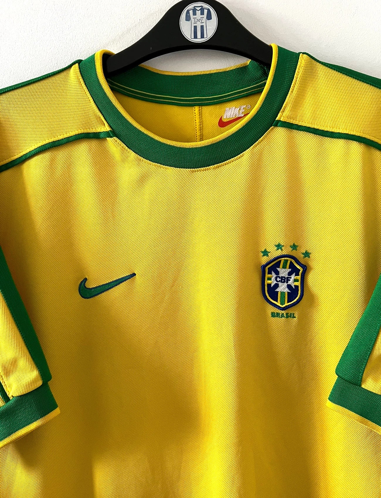Maillot foot vintage domicile Brésil 1998 jaune et vert. On peut retrouver l'équipementier Nike. Il s'agit d'un maillot authentique d'époque.