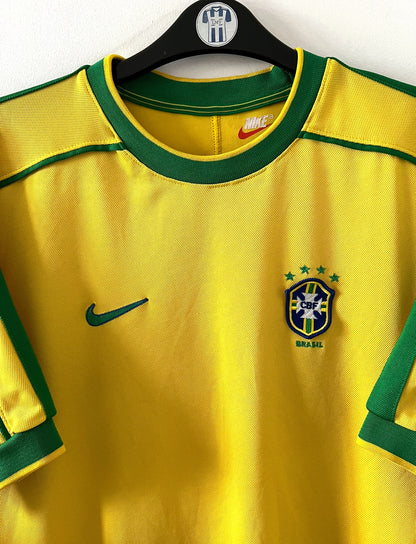 Maillot foot vintage domicile Brésil 1998 jaune et vert. On peut retrouver l'équipementier Nike. Il s'agit d'un maillot authentique d'époque.