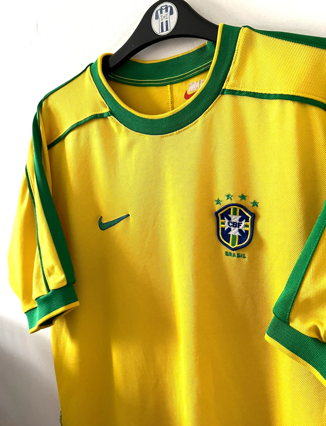Maillot foot vintage domicile Brésil 1998 jaune et vert. On peut retrouver l'équipementier Nike. Il s'agit d'un maillot authentique d'époque.
