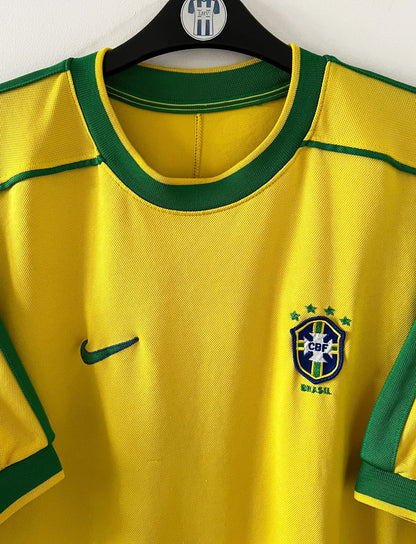 Maillot foot vintage domicile brésil 1998. On peut retrouver l'équipementier Nike. Il s'agit d'un maillot authentique d'époque.