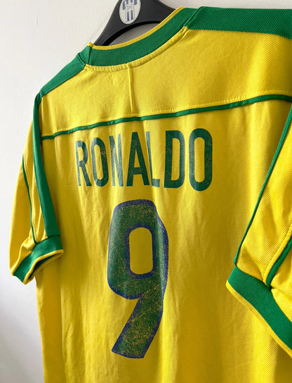 Maillot de foot vintage domicile jaune du Brésil 1998. On peut retrouver l'équipementier Nike. Le maillot est floqué du numéro 9 Ronaldo. Il s'agit d'un maillot authentique d'époque.
