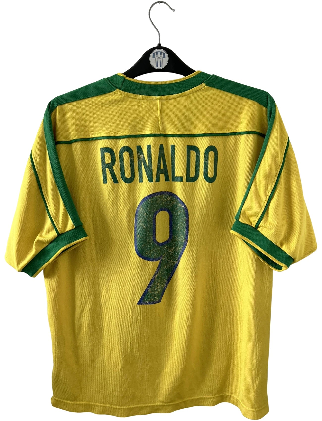 Maillot de foot vintage domicile jaune du Brésil 1998. On peut retrouver l'équipementier Nike. Le maillot est floqué du numéro 9 Ronaldo. Il s'agit d'un maillot authentique d'époque.