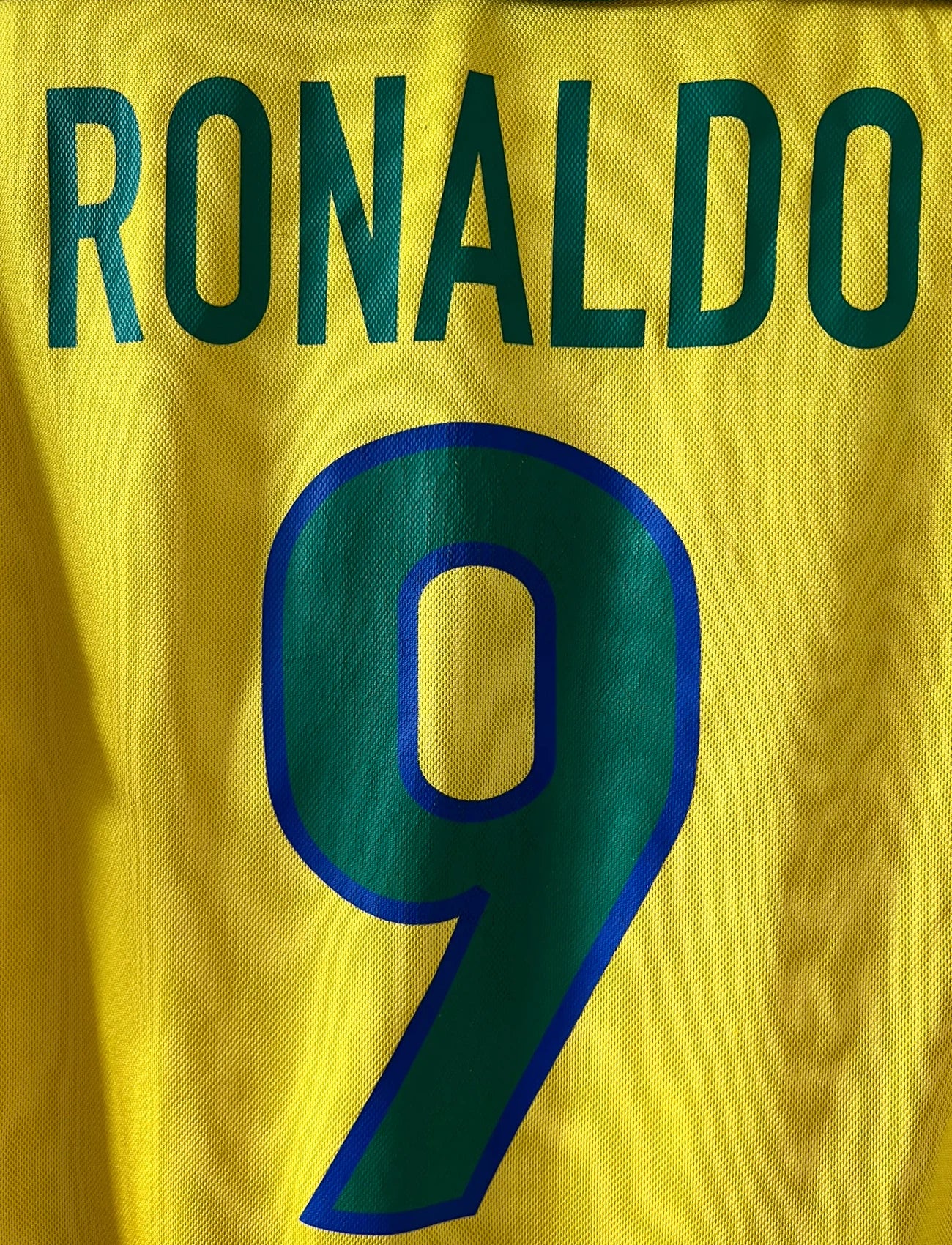 Maillot de foot vintage domicile jaune du Brésil 1998. On peut retrouver l'équipementier Nike. Le maillot est floqué du numéro 9 Ronaldo. Il s'agit d'un maillot authentique d'époque.