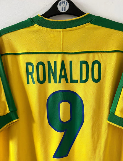 Maillot de foot vintage domicile jaune du Brésil 1998. On peut retrouver l'équipementier Nike. Le maillot est floqué du numéro 9 Ronaldo. Il s'agit d'un maillot authentique d'époque.