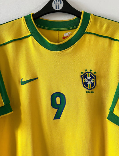 Maillot de foot vintage domicile jaune du Brésil 1998. On peut retrouver l'équipementier Nike. Le maillot est floqué du numéro 9 Ronaldo. Il s'agit d'un maillot authentique d'époque.
