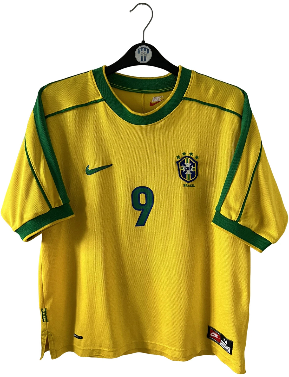 Maillot de foot vintage domicile jaune du Brésil 1998. On peut retrouver l'équipementier Nike. Le maillot est floqué du numéro 9 Ronaldo. Il s'agit d'un maillot authentique d'époque.