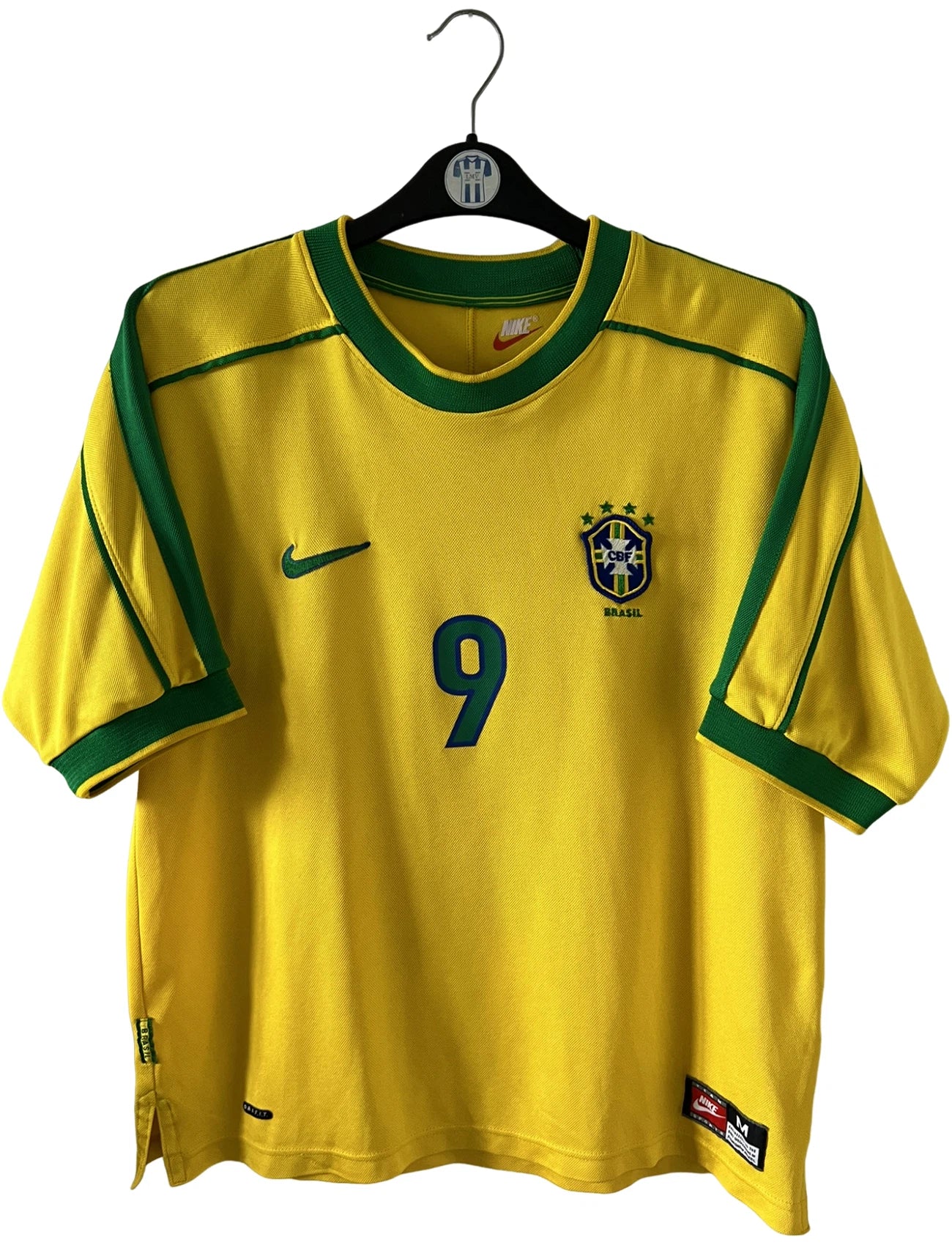 Maillot de foot vintage domicile jaune du Brésil 1998. On peut retrouver l'équipementier Nike. Le maillot est floqué du numéro 9 Ronaldo. Il s'agit d'un maillot authentique d'époque.