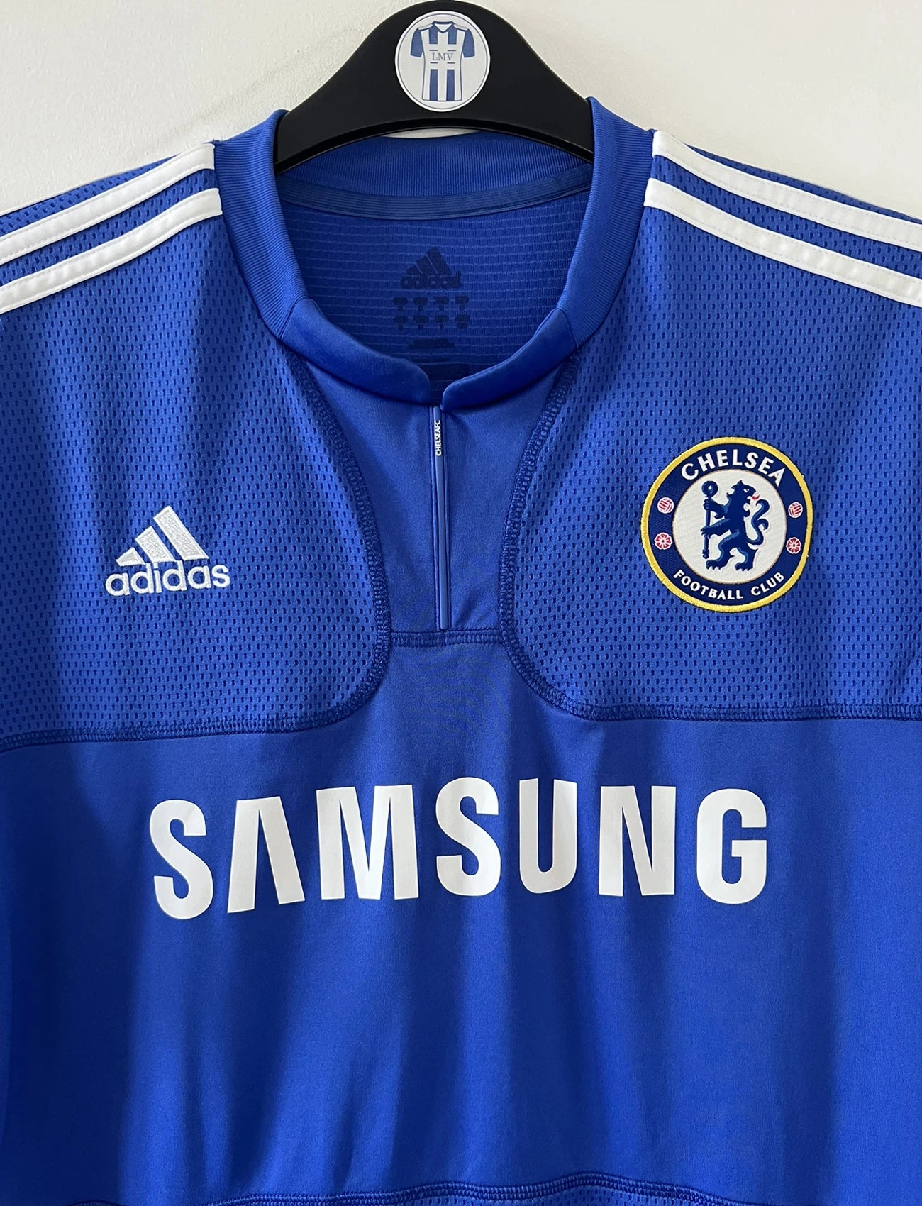 Maillot de foot vinage domicile bleu de chelsea de la saison 2009/2010. On peut retrouver l'équipementier adidas et le sponsor samsung. Le maillot est floqué du numéro 8 Lampard. Il s'agit d'un maillot authentique d'époque comportant les numéros E84291