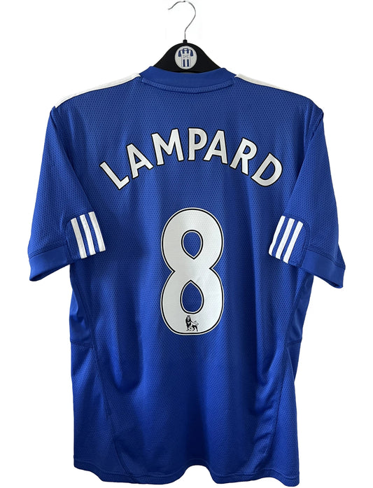 Maillot de foot vinage domicile bleu de chelsea de la saison 2009/2010. On peut retrouver l'équipementier adidas et le sponsor samsung. Le maillot est floqué du numéro 8 Lampard. Il s'agit d'un maillot authentique d'époque comportant les numéros E84291