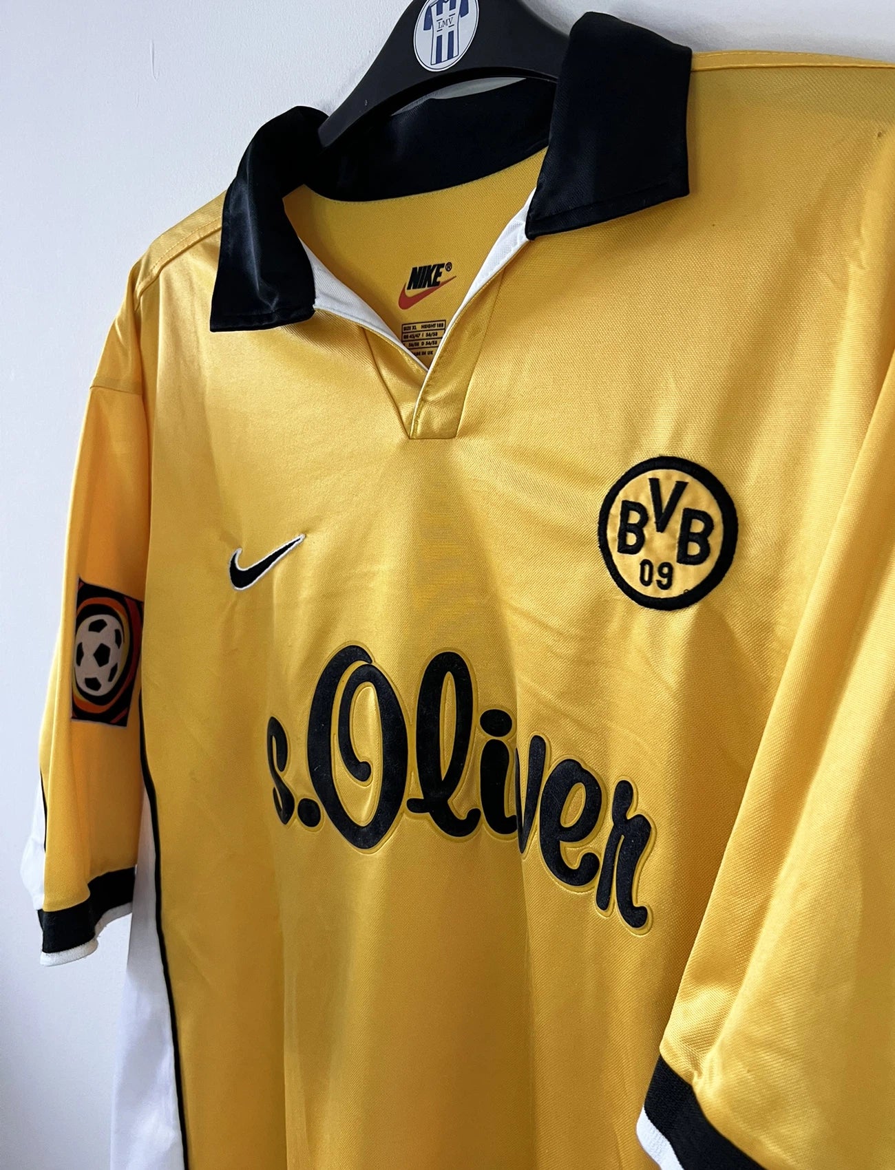 Maillot de foot vintage domicile jaune du borussia dortmund de la saison 1998/1999. On peut retrouver l'équipementier Nike et le sponsor S.Oliver. Le maillot est floqué du numéro 5 Jürgen Kohler. Il s'agit d'un maillot authentique d'époque.