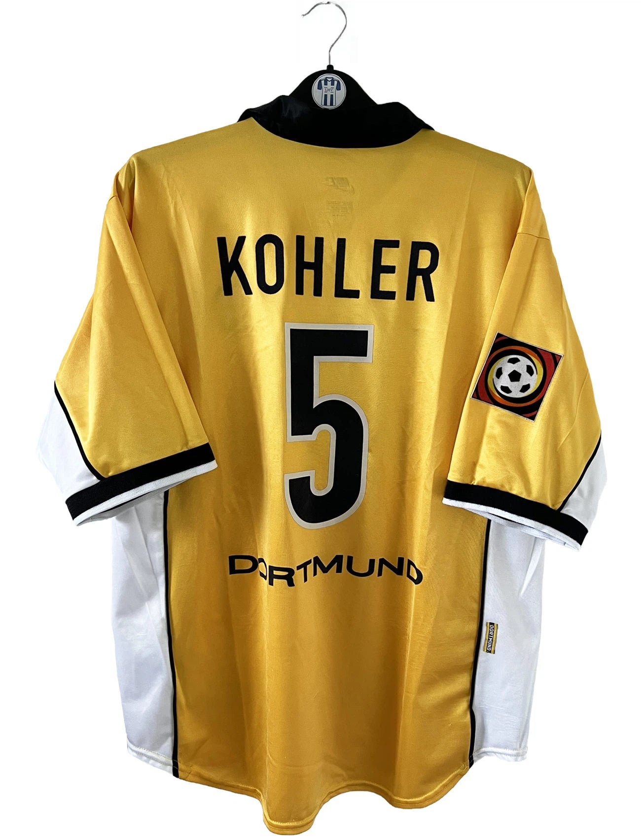 Maillot de foot vintage domicile jaune du borussia dortmund de la saison 1998/1999. On peut retrouver l'équipementier Nike et le sponsor S.Oliver. Le maillot est floqué du numéro 5 Jürgen Kohler. Il s'agit d'un maillot authentique d'époque.
