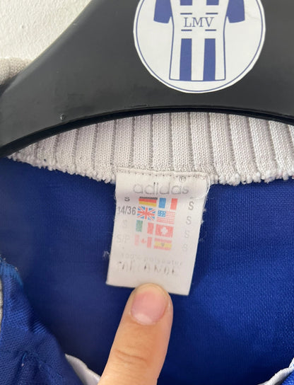 Maillot de foot vintage domicile bleu de l'équipe de france 1996. On peut retrouver l'équipementier Adidas. Il s'agit d'un maillot authentique d'époque.