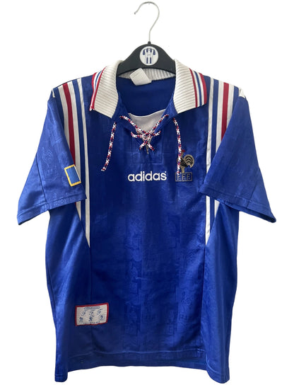 Maillot de foot vintage domicile bleu de l'équipe de france 1996. On peut retrouver l'équipementier Adidas. Il s'agit d'un maillot authentique d'époque.