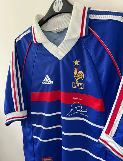 Maillot foot vintage domicile equipe de france 1998 bleu blanc et rouge. On peut retrouver l'équipementier adidas. Le maillot est floqué du numéro 10 Zinedine Zidane. Il s'agit d'un maillot authentique d'époque avec la signature de Zidane en sérigraphié.