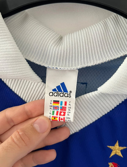 Maillot foot vintage domicile equipe de france 1998 bleu blanc et rouge. On peut retrouver l'équipementier adidas. Le maillot est floqué du numéro 10 Zinedine Zidane. Il s'agit d'un maillot authentique d'époque avec la signature de Zidane en sérigraphié.