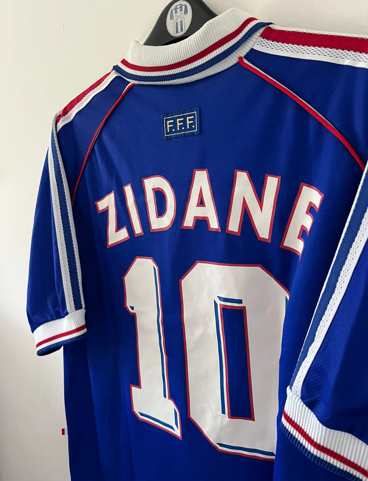 Maillot foot vintage domicile equipe de france 1998 bleu blanc et rouge. On peut retrouver l'équipementier adidas. Le maillot est floqué du numéro 10 Zinedine Zidane. Il s'agit d'un maillot authentique d'époque avec la signature de Zidane en sérigraphié.
