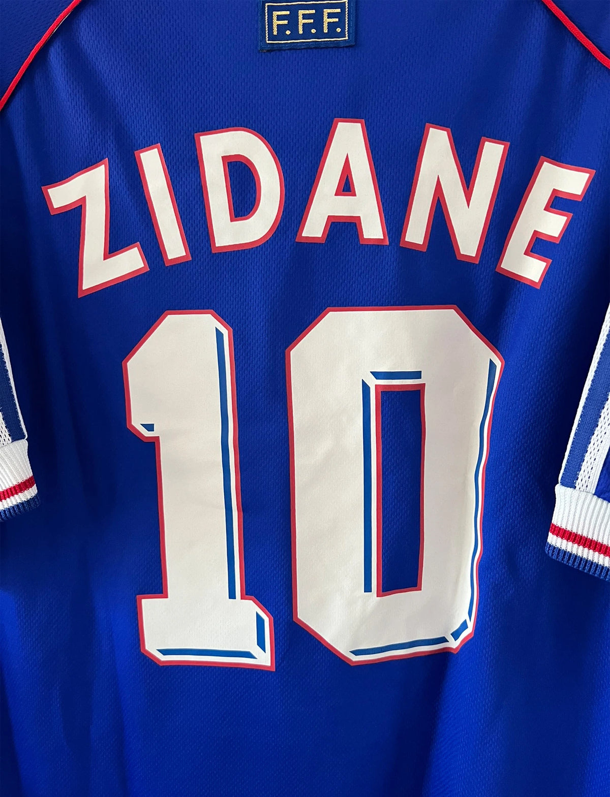 Maillot foot vintage domicile equipe de france 1998 bleu blanc et rouge. On peut retrouver l'équipementier adidas. Le maillot est floqué du numéro 10 Zinedine Zidane. Il s'agit d'un maillot authentique d'époque avec la signature de Zidane en sérigraphié.