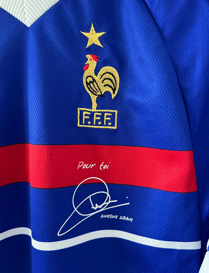 Maillot foot vintage domicile equipe de france 1998 bleu blanc et rouge. On peut retrouver l'équipementier adidas. Le maillot est floqué du numéro 10 Zinedine Zidane. Il s'agit d'un maillot authentique d'époque avec la signature de Zidane en sérigraphié.