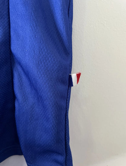 Maillot de foot vintage bleu, blanc et rouge de l'équipe de france 1998. On peut retrouver l'équipementier adidas. Il s'agit d'un maillot authentique édité avant la finale de la coupe du monde car celui-ci ne possède pas l'étoile. Le maillot possède la mention pour toi avec la signature de zidane