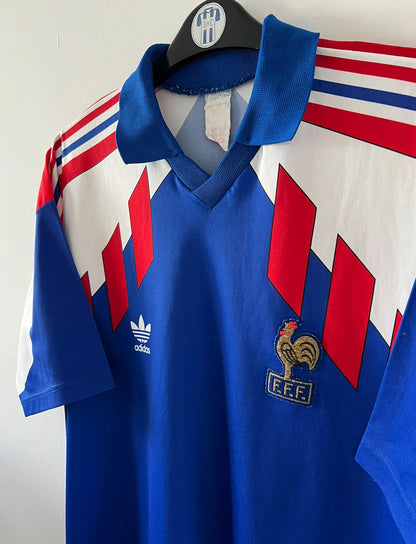 Maillot de foot vintage domicile bleu de l'équipe de france 1990/1992. On peut retrouver l'équipementier Adidas. Il s'agit d'un maillot authentique d'époque.