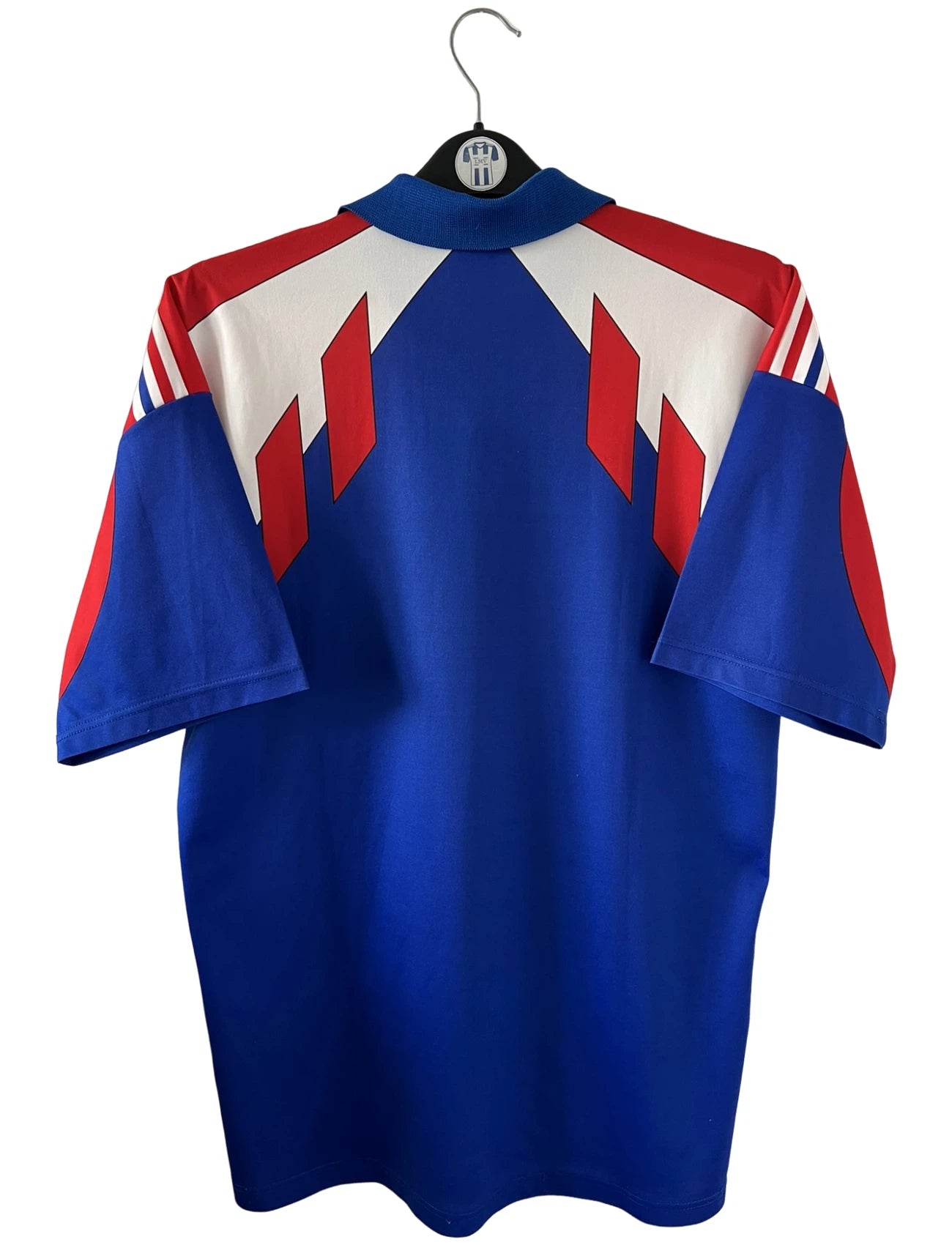 Maillot de foot vintage domicile bleu de l'équipe de france 1990/1992. On peut retrouver l'équipementier Adidas. Il s'agit d'un maillot authentique d'époque.