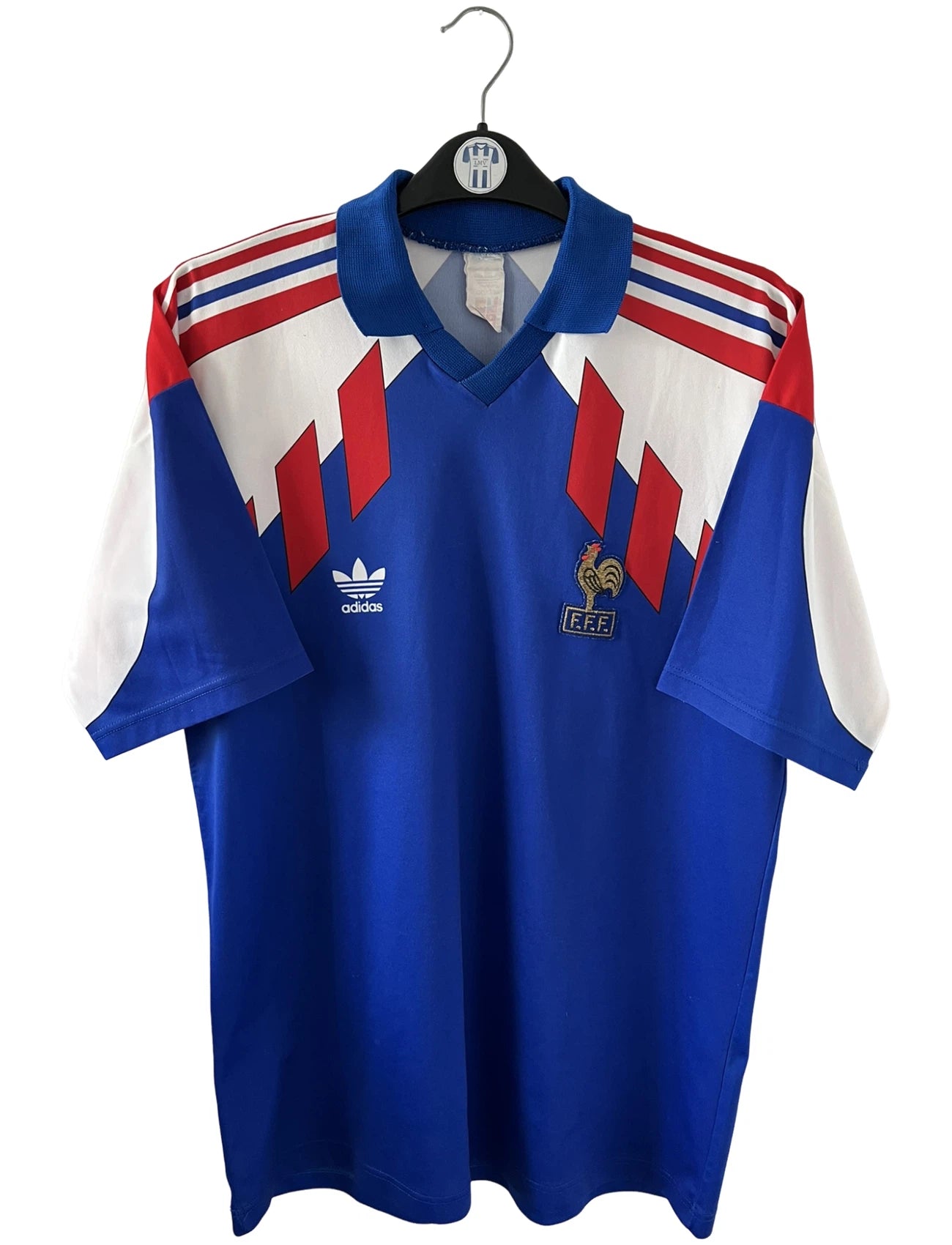 Maillot de foot vintage domicile bleu de l'équipe de france 1990/1992. On peut retrouver l'équipementier Adidas. Il s'agit d'un maillot authentique d'époque.