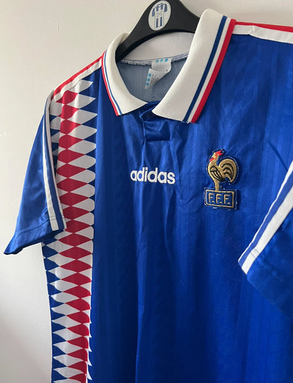 Maillot de foot vintage domicile bleu de l'Equipe de France 1994. On peut retrouver l'équipementier Adidas. Il s'agit d'un maillot authentique d'époque.