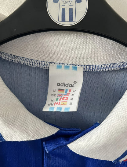 Maillot de foot vintage domicile bleu de l'Equipe de France 1994. On peut retrouver l'équipementier Adidas. Il s'agit d'un maillot authentique d'époque.